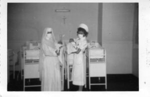 Sister ministering to patients, 1952, infant, baby, newborn, with nurse.